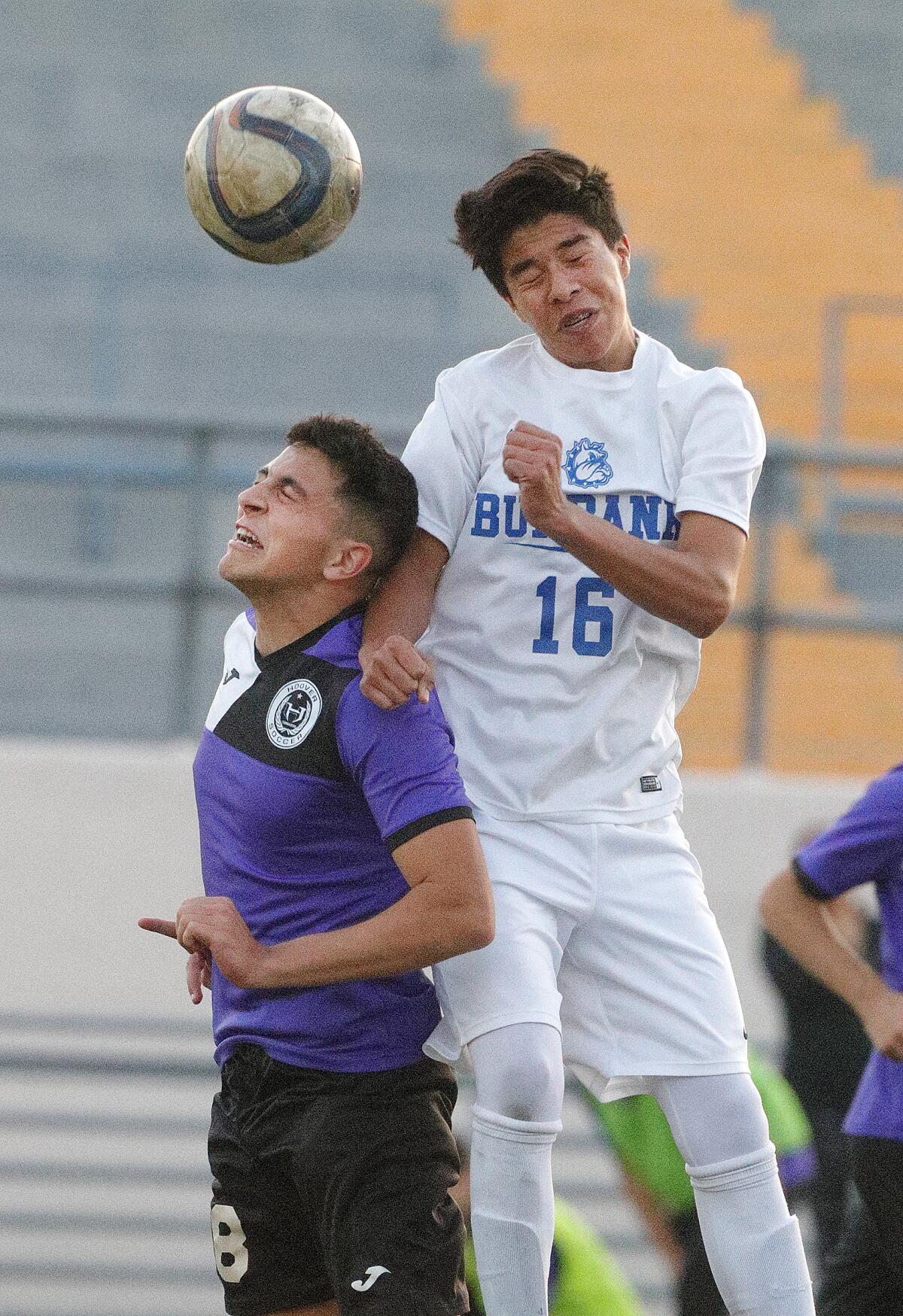 Burbank’s Freddy Cardenas, right, heads the ball over Hoover’s Sevak Papazyan in a Pacific League boys' soccer game at Hoover High School on Friday, January 3, 2020.