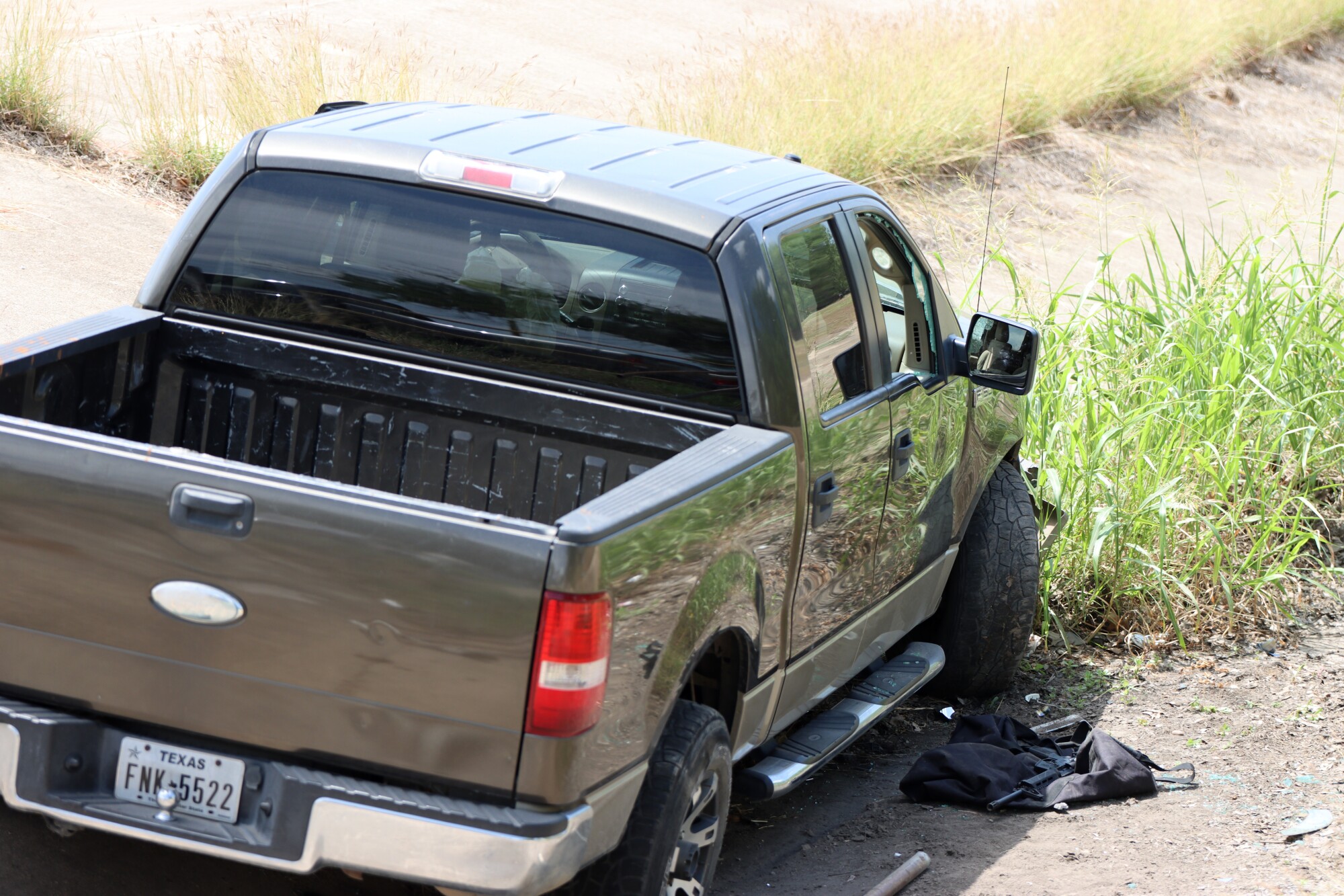 A weapon lays next to the shooters crashed truck near the school site in Uvalde, Texas.