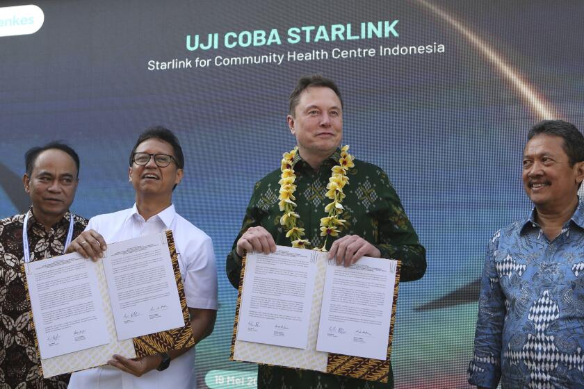 Indonesian Minister of Health Budi Gunadi Sadikin, second from left, and Elon Musk, second from right, sign an agreement on enhancing connectivity at a public health center in Denpasar, Bali, Indonesia on Sunday, May 19, 2024. Elon Musk arrived in Indonesia's resort island of Bali to launch Starlink satellite internet service in the world's largest archipelago nation. (AP Photo/Firdia Lisnawati)