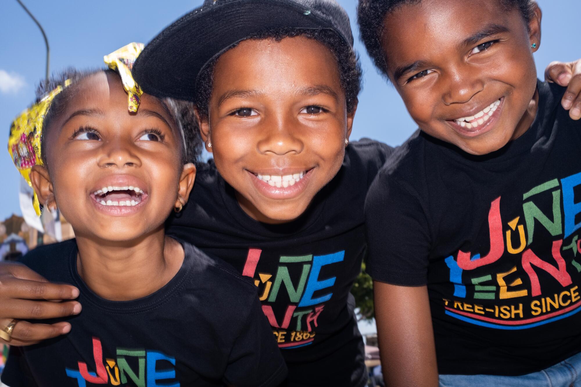 Siblings Caleb, Jacob and Grace wear Juneteenth T-shirts that say "Free-ish since 1865."