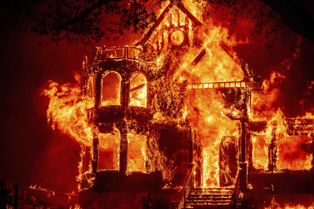 The two-story Black Rock Inn is fully engulfed in flames.