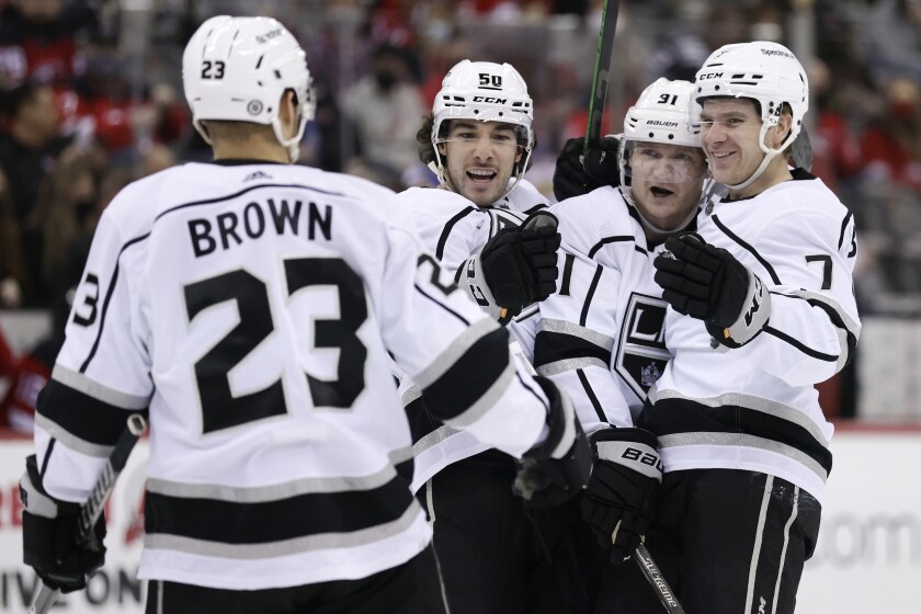 Los Angeles Kings right wing Carl Grundstrom (91) is congratulated by teammates after scoring a goal during the third period of an NHL hockey game against the New Jersey Devils, Sunday, Jan. 23, 2022, in Newark, N.J. (AP Photo/Adam Hunger)