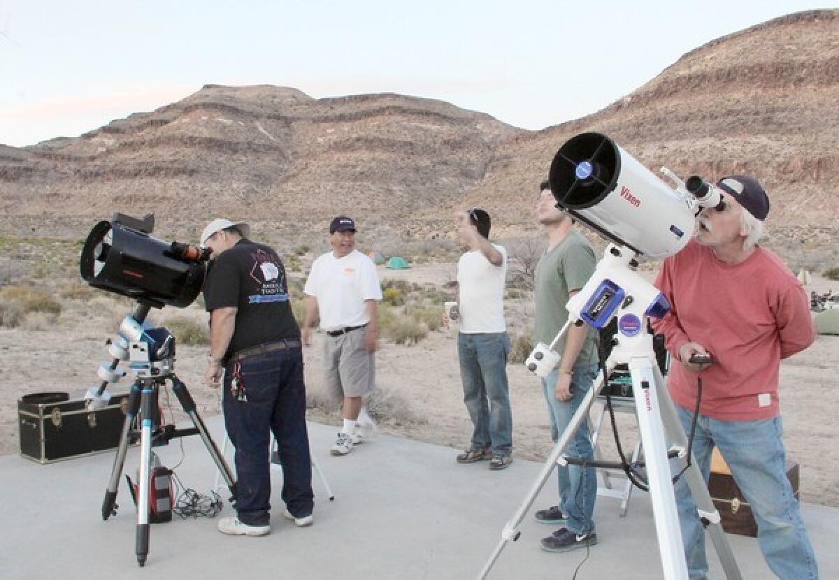 Stargazers look at the moon and visible planets before the sun sets during a public star party at the Mojave National Preserve on Saturday, May 11, 2013. Members of the Old Town Sidewalk Astronomers, made up of residents from the San Gabriel Valley, have arranged the free events in the Mojave desert since 2008.