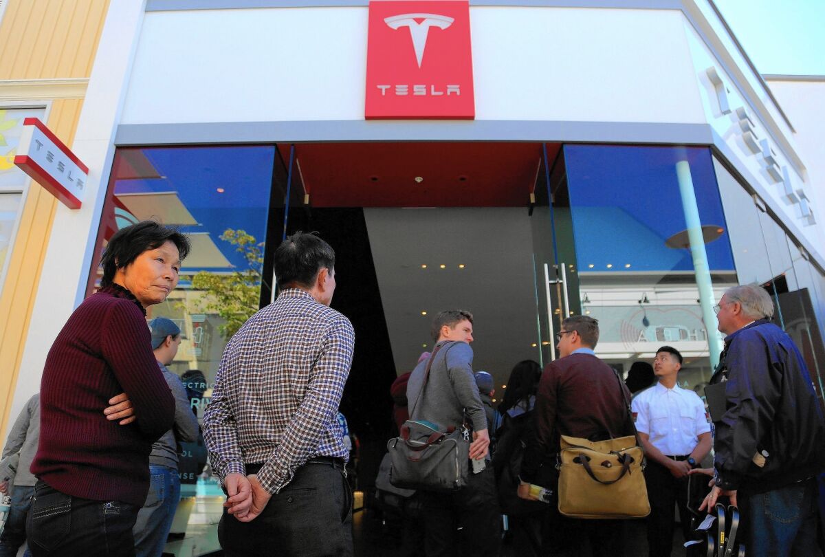 Car buyers at a La Jolla dealership wait in line last month to plunk down $1,000 to reserve Tesla's newest electric car, the $35,000 Model 3 sedan.