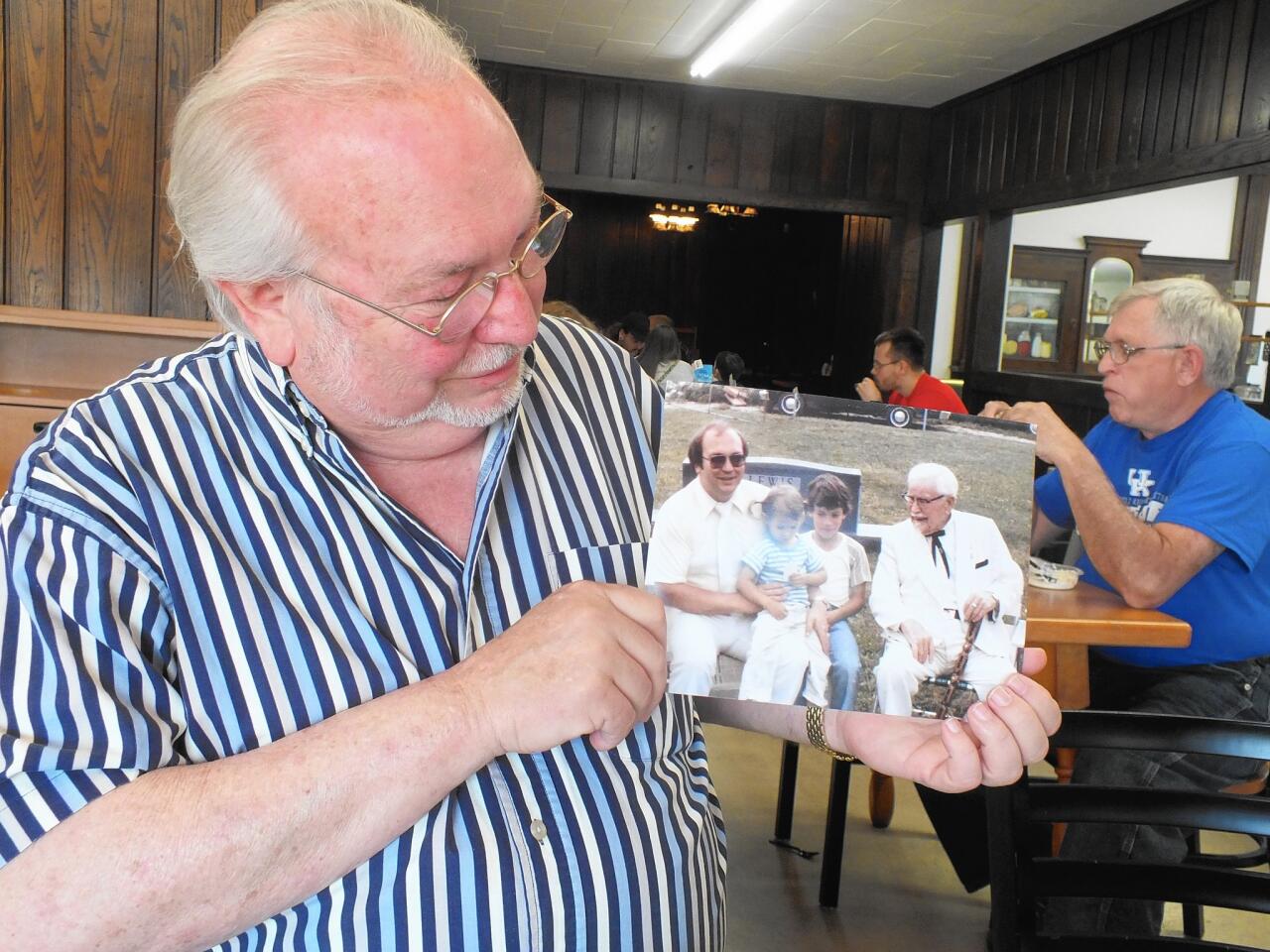 Joe Ledington of Corbin, Ky., displays a 1980s photo of him with his uncle, Colonel Harland Sanders, who perfected his world-famous Kentucky Fried Chicken in his Corbin cafe. The photo is part of a family album.