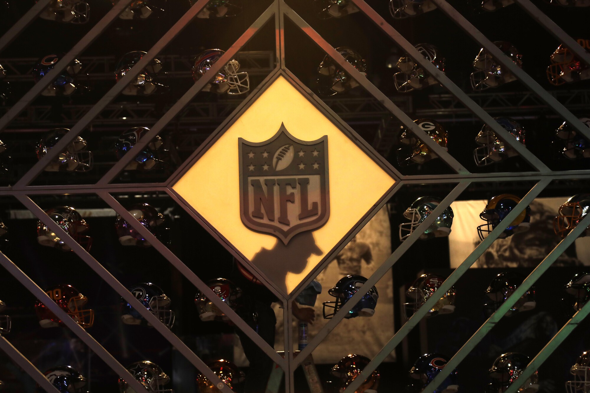 The NFL logo appears with a display of team helmets