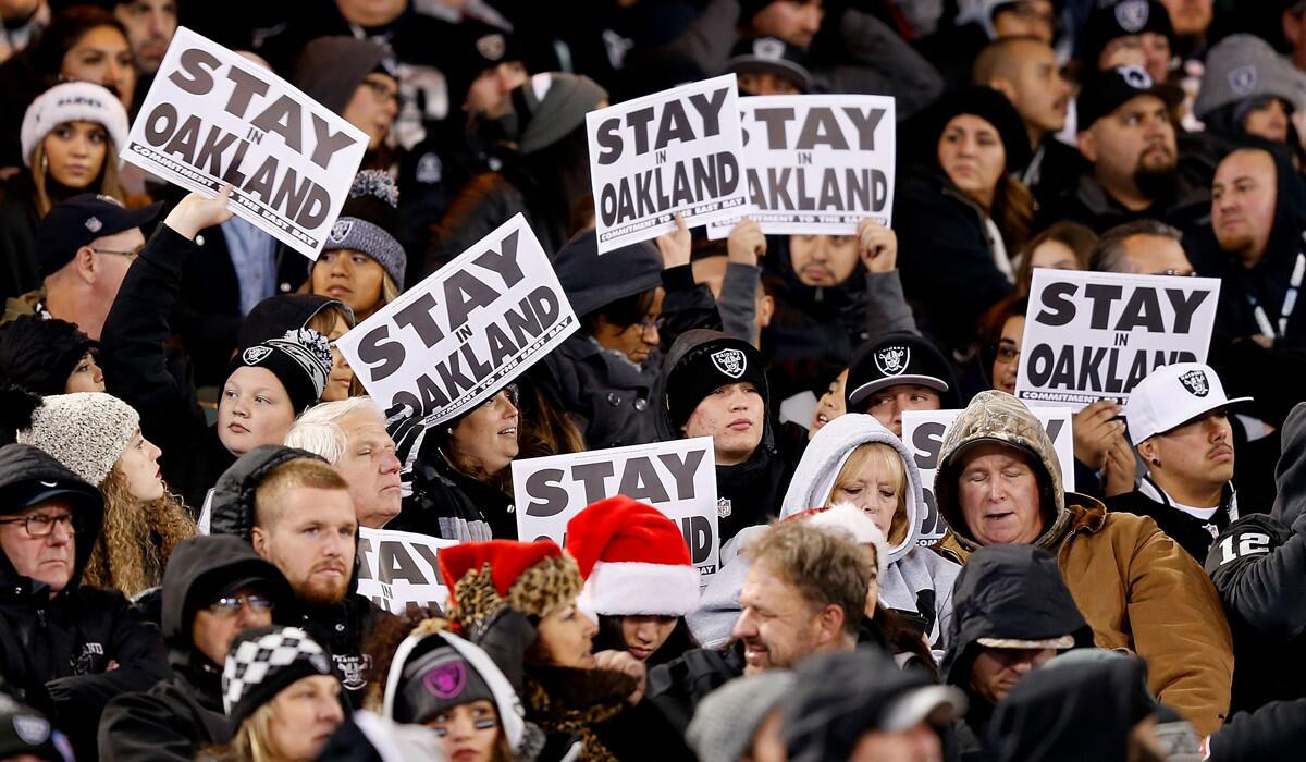 Oakland Raiders fans show "Stay In Oakland" signs during the game against the San Diego Chargers on Dec. 24.