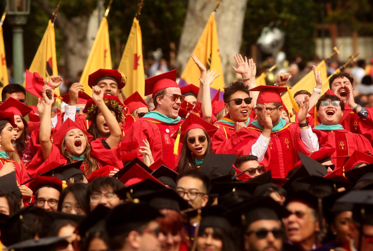 USC graduates in caps and gowns cheer at the school's commencement on May 12, 2023. 