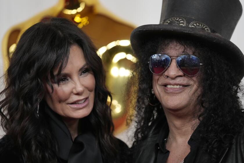 Meegan Hodges, left, and Slash arrive at the Oscars on Sunday, March 10, 2024, at the Dolby Theatre in Los Angeles. (AP Photo/Ashley Landis)