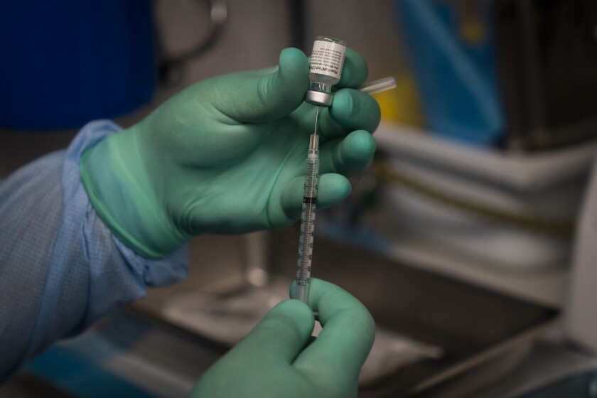 A syringe of COVID-19 vaccine is prepared in a mobile clinic in Santa Ana. 