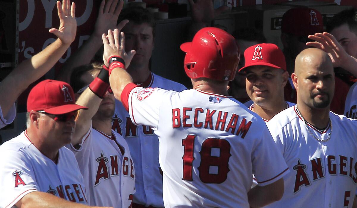 Angels shortstop Gordon Beckham gets high-fives in the dugout after scoring what would be the Angels' only run against the Astros in the eighth inning Sunday in Anaheim.