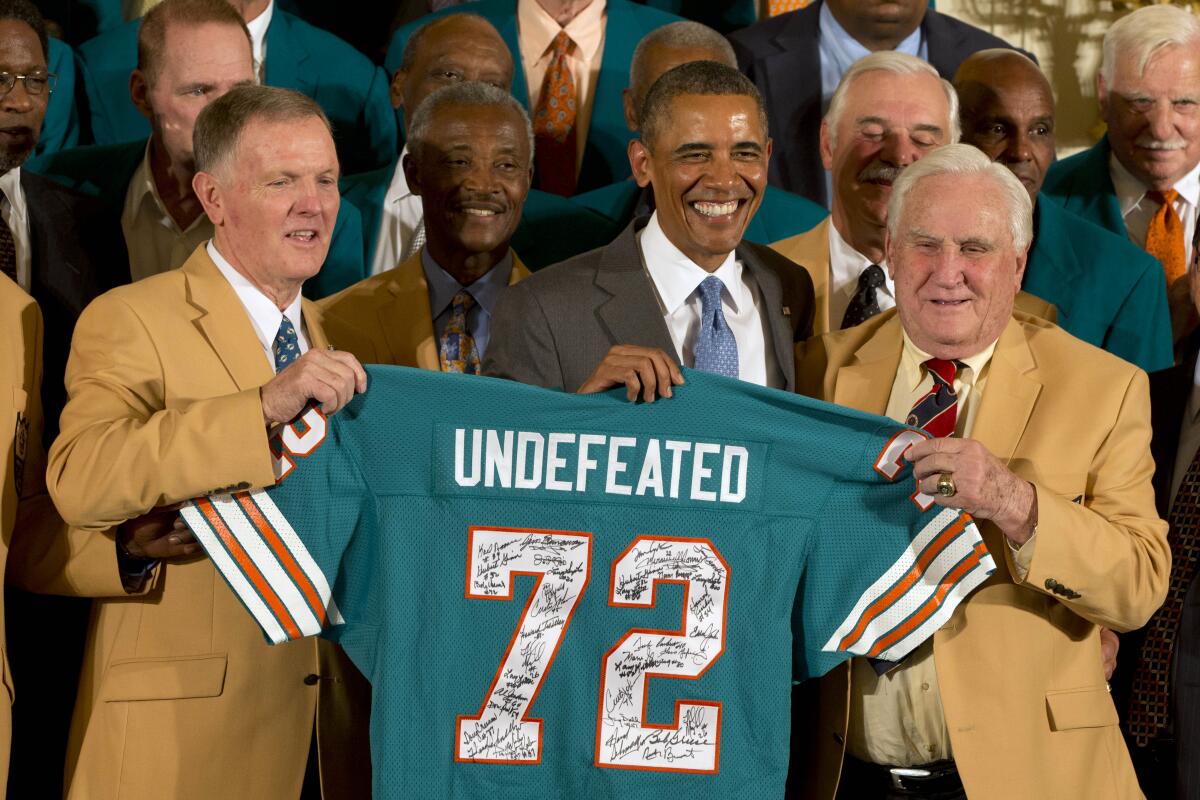 Bob Griese (left), President Barack Obama and Miami coach Don Shula hold a jersey during a White House ceremony in 2013.