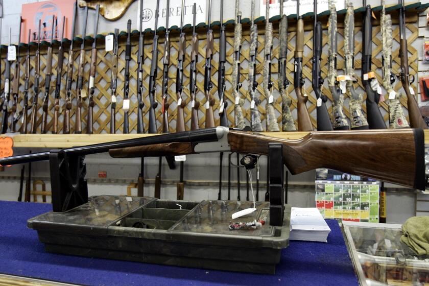 FILE - In a May 16, 2006 file photo, rifles line a hunting store's shelves in Ottawa. Prime Minister Justin Trudeau said Friday, May 1, 2020 that Canada is banning the use and trade of assault-style weapons immediately. (Jonathan Hayward/The Canadian Press via AP)