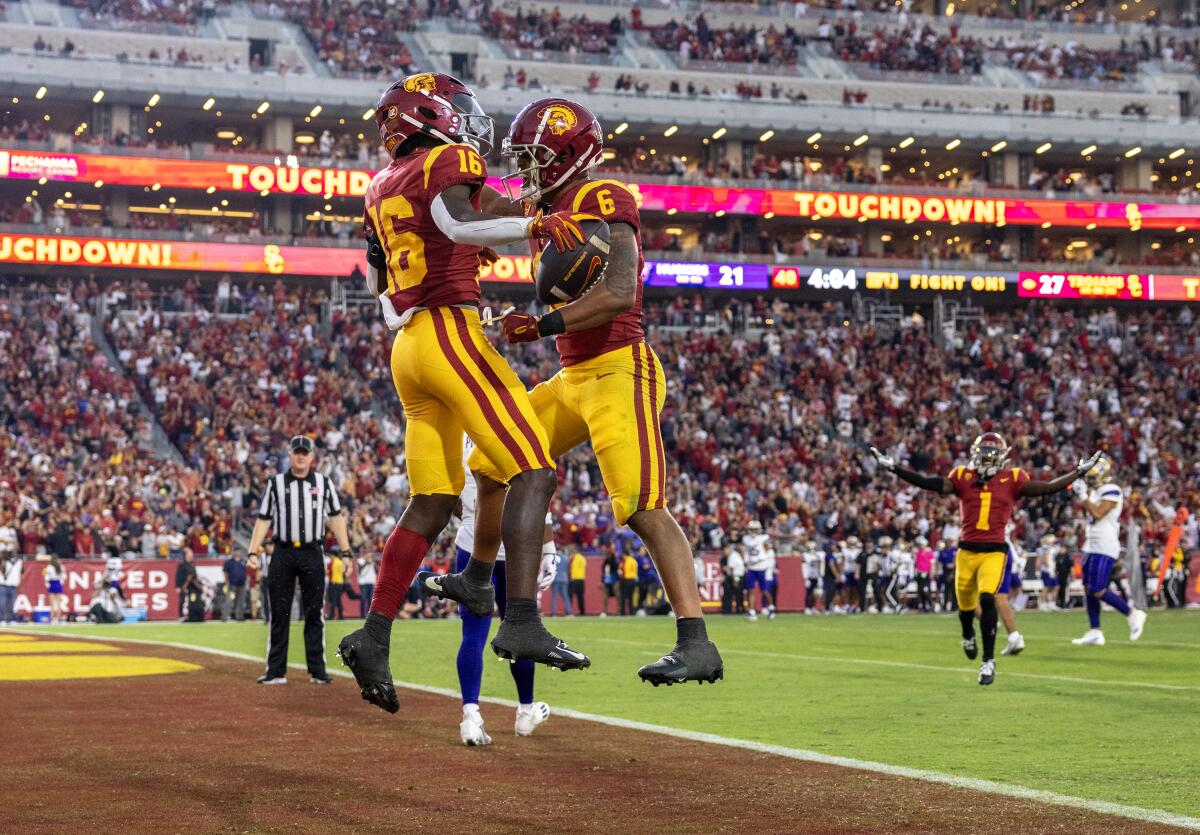 USC wide receiver Tahj Washington, left, celebrates with running back Austin Jones after scoring a touchdown.
