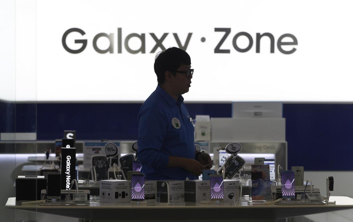 A man passes by Samsung Electronics Galaxy Note 7 smartphones at the company's shop in Seoul. Samsung Electronics has temporarily halted production of its Galaxy Note 7 after reports that they too could malfunction and explode.