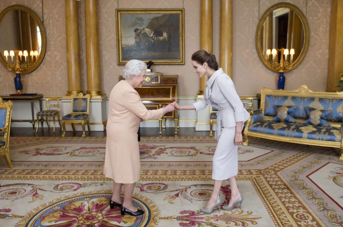 Angelina Jolie is presented with the Insignia of an Honorary Dame Grand Cross of the Most Distinguished Order of St. Michael and St. George by Queen Elizabeth II in the 1844 Room at Buckingham Palace on Oct. 10