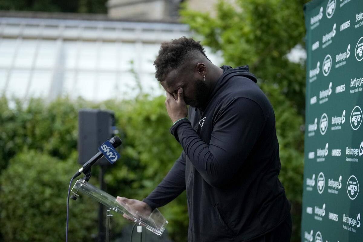 New York Jets' defensive lineman John Franklin-Myers is overcome with emotion as he speaks about signing his new contract during a press conference after an NFL practice session at Hanbury Manor Marriott Hotel and Country Club near the town of Ware in south east England, Friday, Oct. 8, 2021. The New York Jets are preparing for an NFL regular season game against the Atlanta Falcons in London on Sunday. (AP Photo/Matt Dunham)
