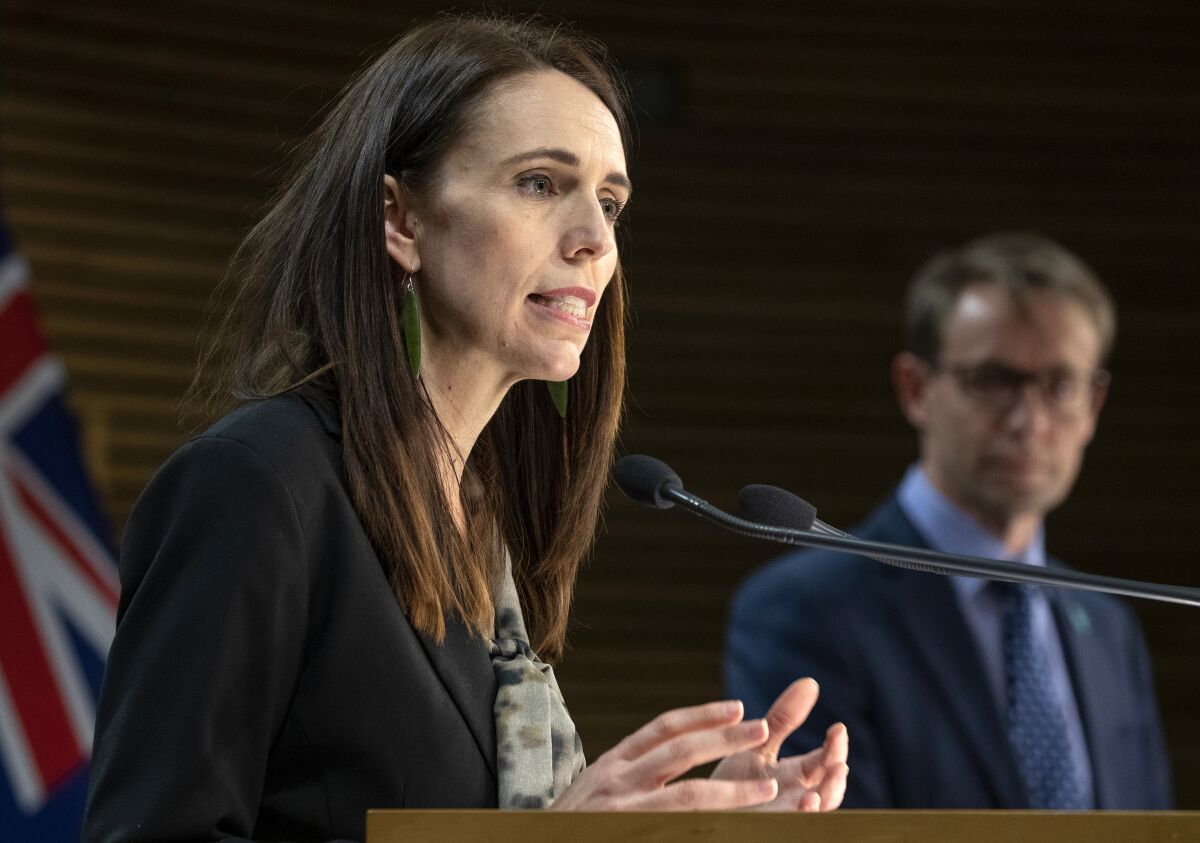 New Zealand Prime Minister Jacinda Ardern, left, and Director of Health Ashley Bloomfield address a press conference in Wellington, New Zealand, Wednesday, Aug. 12, 2020. Authorities have found four cases of the coronavirus in one Auckland household from an unknown source, the first reported cases of local transmission in the country in 102 days. The news came as an unpleasant surprise and raised questions about whether the nation's general election would go ahead as planned next month. (Mark Mitchell/New Zealand Herald via AP)