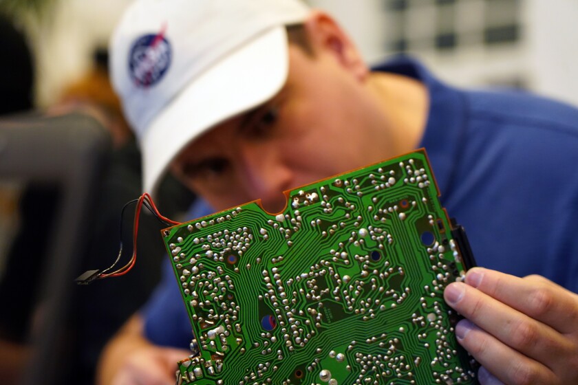 A volunteer repairs a circuit board at a fortnightly repair cafe event in Malmo, southern Sweden, Sunday Nov. 14, 2021. A global network of free-of-charge repair, made by non-professionals with a bug for fixing things, comes at a time as many electronics and white goods are discarded although they could be fixed. The shops, the so-called Repair Cafes, are part of an international grassroot network calling for the “Right to Repair.” (AP Photo/James Brooks)