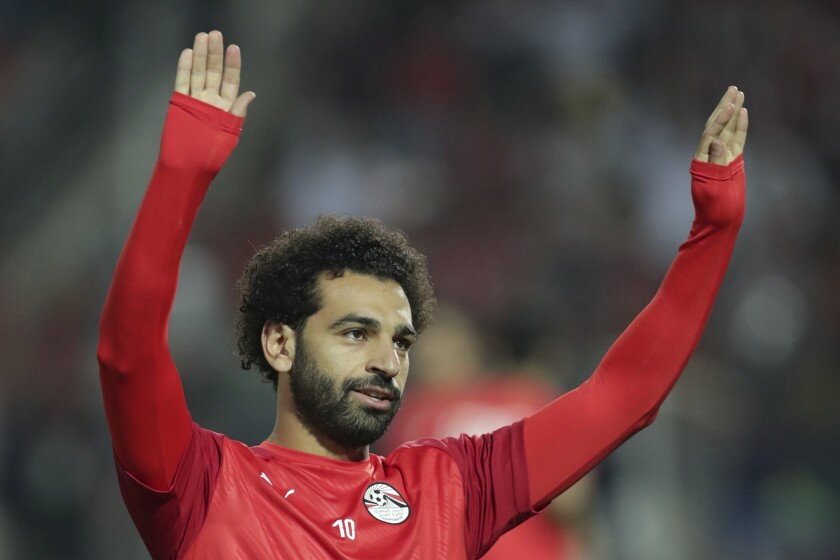 FILE - Egypt's Mohamed Salah applauds fans prior to the start of the African Cup of Nations round of 16 soccer match between Egypt and South Africa in Cairo International stadium in Cairo, Egypt, Saturday, July 6, 2019. South Africa won 1-0. The African Cup of Nations soccer tournament will finally open in Cameroon on Sunday, Jan. 9, 2022 after two delays. The Central African country was stripped of the 2019 tournament because of its own faulty preparations and then its hosting in 2021 was delayed a year because of the coronavirus pandemic. African soccer's biggest tournament has come around with the virus surging again because of the new omicron variant and organizers have resisted calls that it should be postponed once more or even canceled. (AP Photo/Hassan Ammar, File)