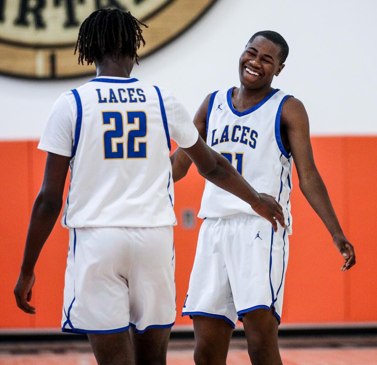 Emmanuel Duru, right, smiles as he receives encouragement from LACES teammate Joshua Sangster.