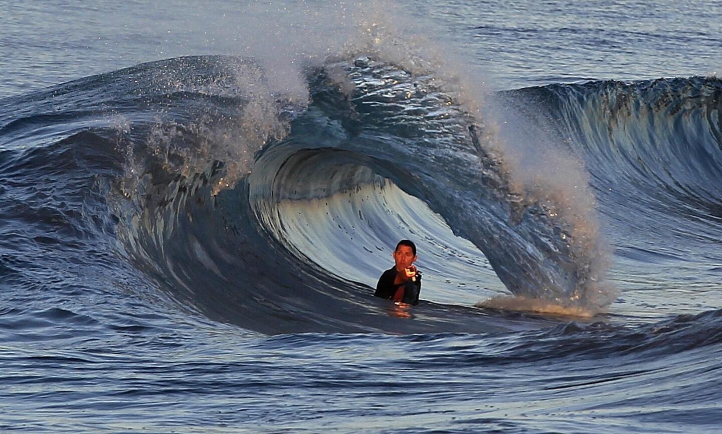 A swimmer with a GoPro photographs the surf at The Wedge in Newport Beach Harbor Thursday morning. A tsunami surge from a huge earthquake in Chile hit the Southern California coast causing tide fluctuations of up to a foot.