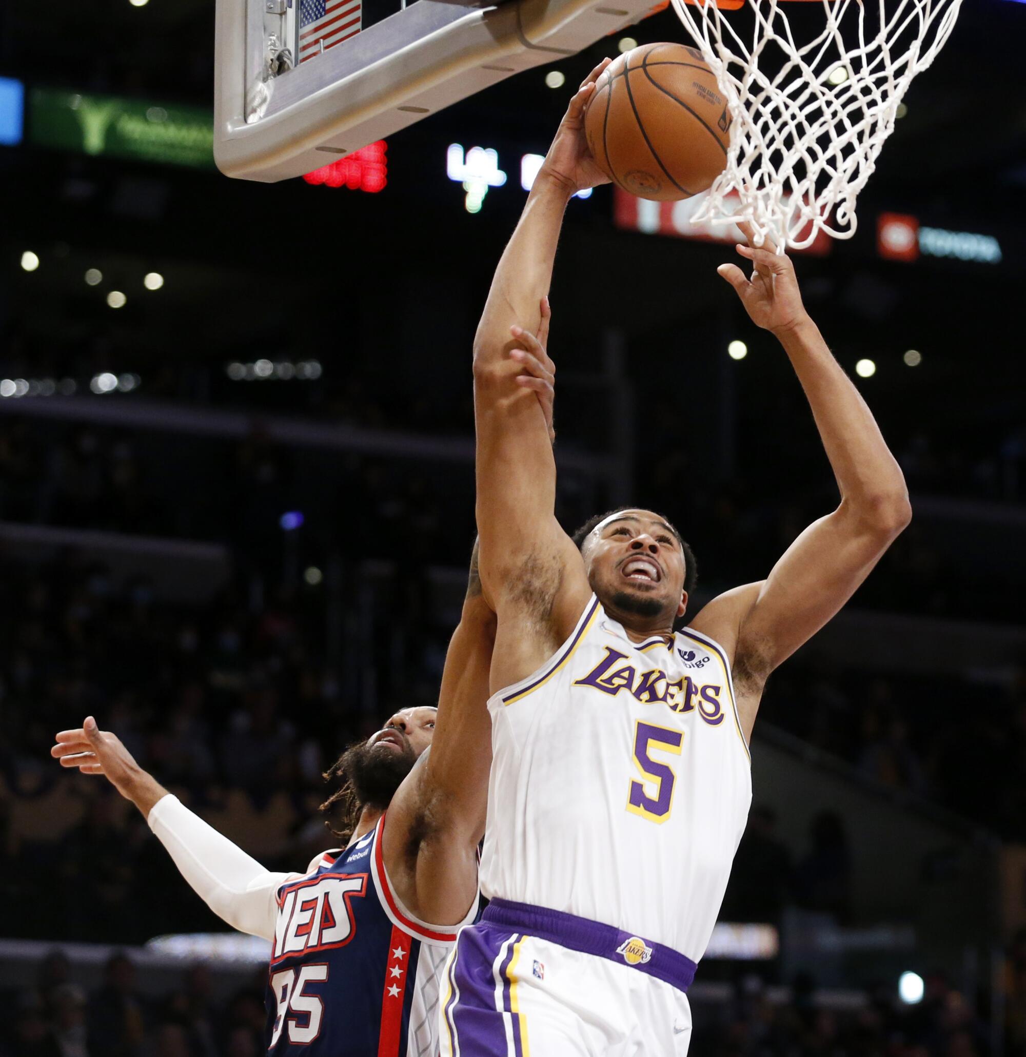 Lakers guard Talen Horton-Tucker drives to the basket in front of Brooklyn Nets guard DeAndre' Bembry in the first half.