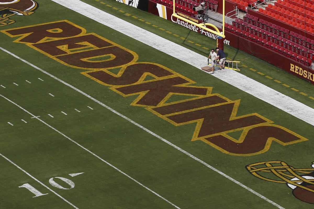 Groundskeepers prepare FedEx Field in Landover, Md., for a preseason game between the Washington Redskins and the New England Patriots last month.