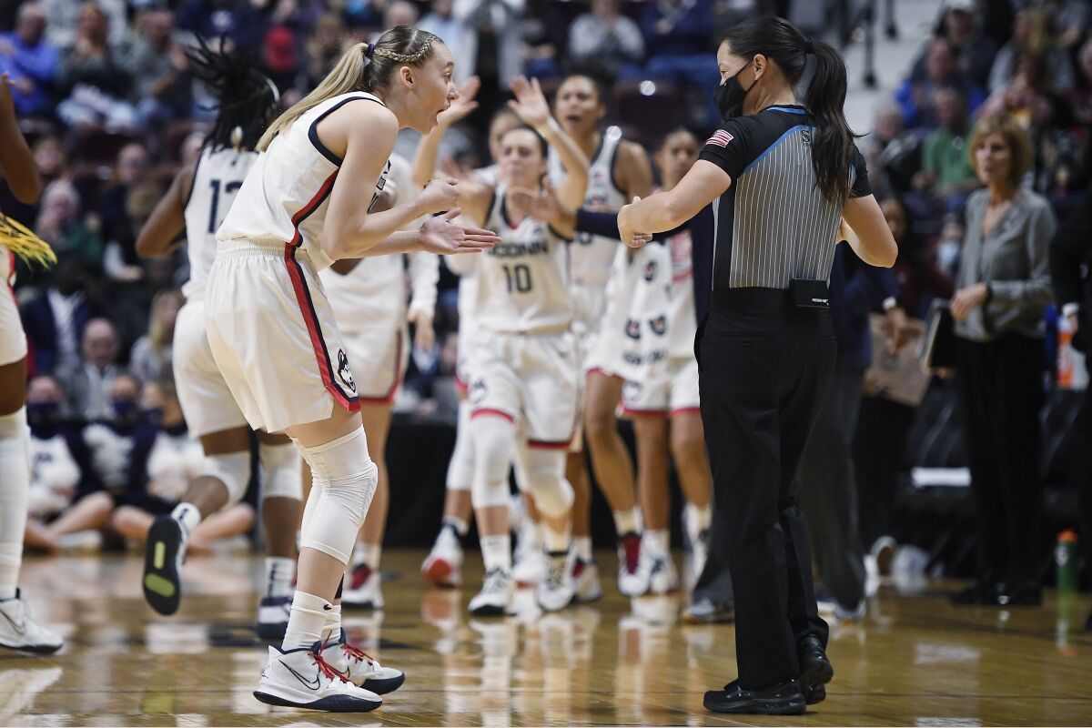 Connecticut's Paige Bueckers, left, talks with official Maj Forsberg during the first half of an NCAA college basketball game against Georgetown in the quarterfinals of the Big East Conference tournament at Mohegan Sun Arena, Saturday, March 5, 2022, in Uncasville, Conn. (AP Photo/Jessica Hill)