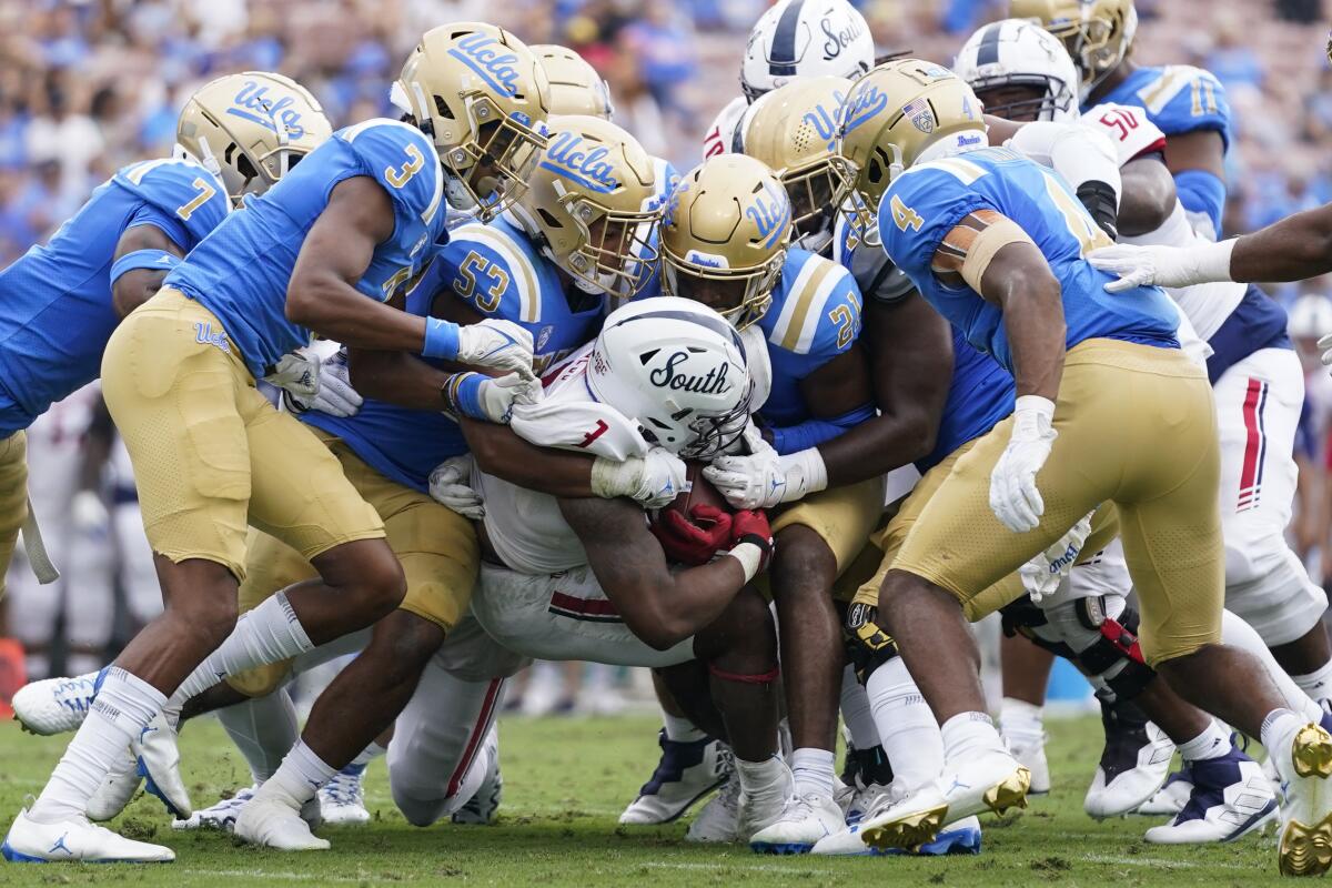 South Alabama running back La'Damian Webb is tackled by UCLA defenders on Sept. 17 at the Rose Bowl.