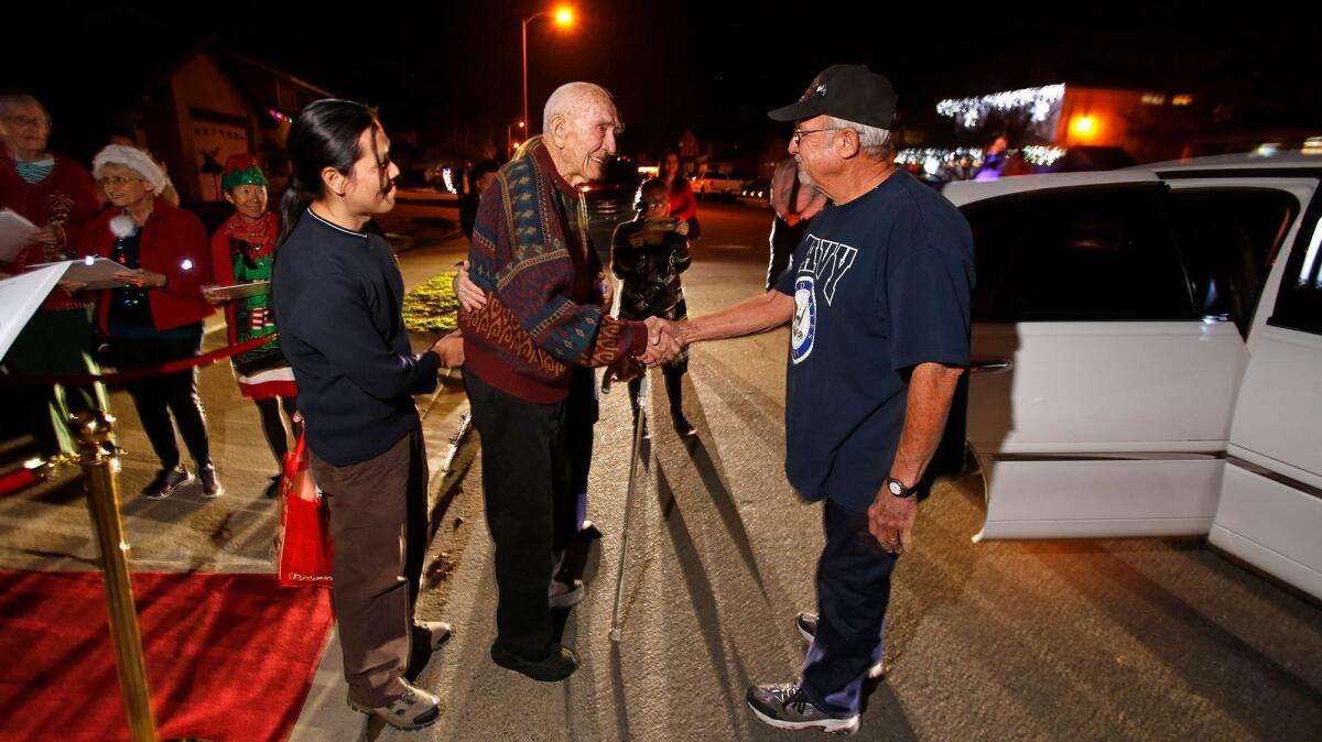 Navy veteran Carl Morgan shakes hands with a fellow vet before getting into a limousine during the Lights and Limos event courtesy of his hospice provider on Dec. 11 in Lake Forest.