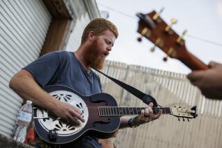 FARMVILLE, VIRGINIA - AUGUST 26: Christopher Anthony Lunsford (left), who goes by the stage name Oliver Anthony, warms up with his guitarist Joey Davis (right) next to a loading dock behind the buildings lining Main Street before a surprise performance at the Rock the Block street festival on August 26, 2023 in Farmville, Virginia. Anthony's song "Rich Men North of Richmond" gained notoriety after it was played at the recent Republican presidential primary debate. (Photo by Samuel Corum/Getty Images)