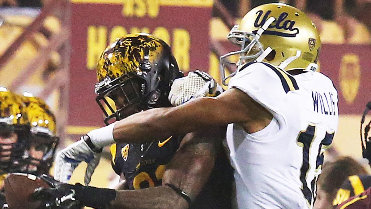 Arizona State wide receiver Jaelen Strong, left, makes a catch in front of UCLA defensive back Priest Willis.