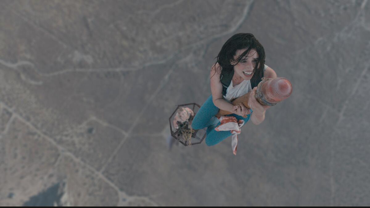 Two women perched on a small platform high in the sky.