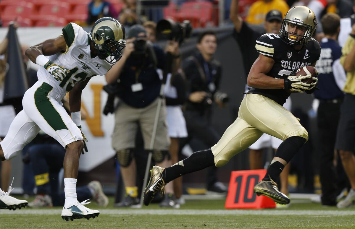 Colorado wide receiver Nelson Spruce, right, runs for the goal line after pulling in a pass for a 54-yard touchdown, beating Colorado State defensive back DeAndre Elliott in the first quarter on Aug. 29, 2014.