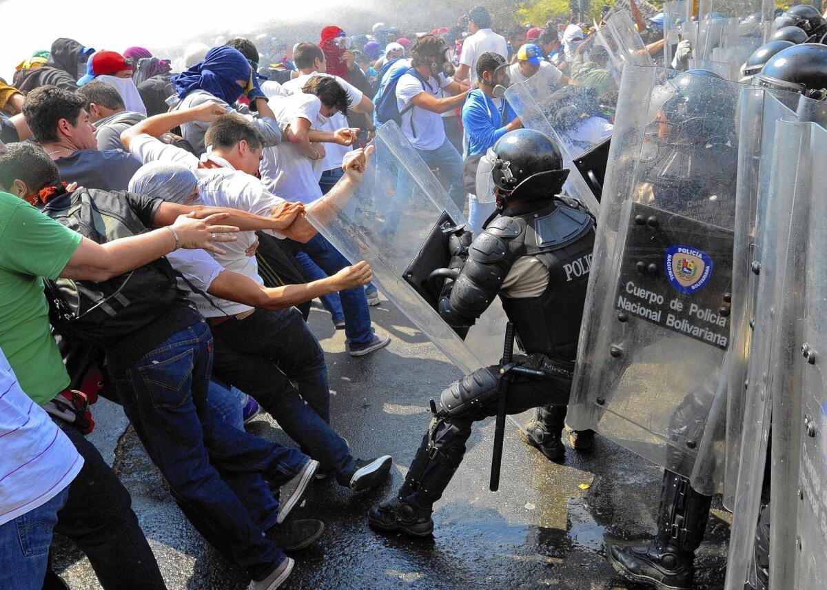 Venezuelan students demonstrating against the government battle riot police in Caracas, the capital.