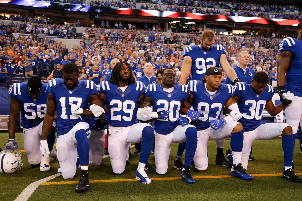 Members of the Indianapolis Colts stand and kneel for the national anthem prior to the start of a Sept. 24 game against the Cleveland Browns at Lucas Oil Stadium in Indianapolis. (Michael Reaves / Getty Images)