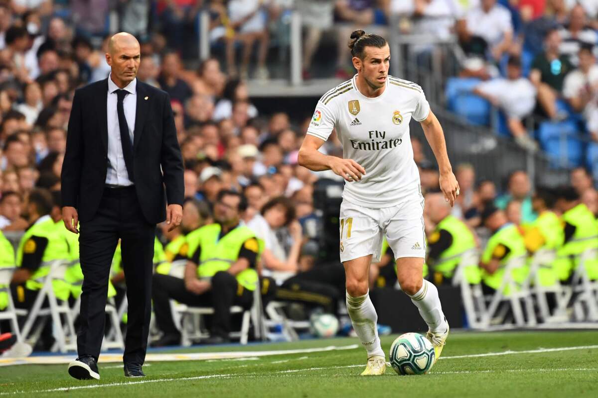(FILES) In this file photo taken on August 24, 2019 Real Madrid's French coach Zinedine Zidane (L) looks at Real Madrid's Welsh forward Gareth Bale (R) during the Spanish League football match between Real Madrid and Real Valladolid at the Santiago Bernabeu stadium in Madrid. - Zinedine Zidane faces another crossroads in his handling of Gareth Bale, who appeared to mock Real Madrid after Wales' 2-0 victory over Hungary. After sealing qualification for Euro 2020 with a wild win in Cardiff, an ecstatic Bale celebrated next to his teammates behind a flag that read "Wales. Golf. Madrid. In that order". (Photo by GABRIEL BOUYS / AFP) (Photo by GABRIEL BOUYS/AFP via Getty Images) ** OUTS - ELSENT, FPG, CM - OUTS * NM, PH, VA if sourced by CT, LA or MoD **