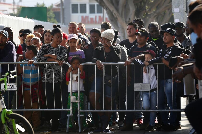 Nelvin C. Cepeda  U-T Hundreds wait early Tuesday morning in Tijuana to go to the U.S. border to meet with U.S. immigration officials. Under the new rule, migrants arriving on the southwest border must first file for safe haven in another country en route to the U.S.