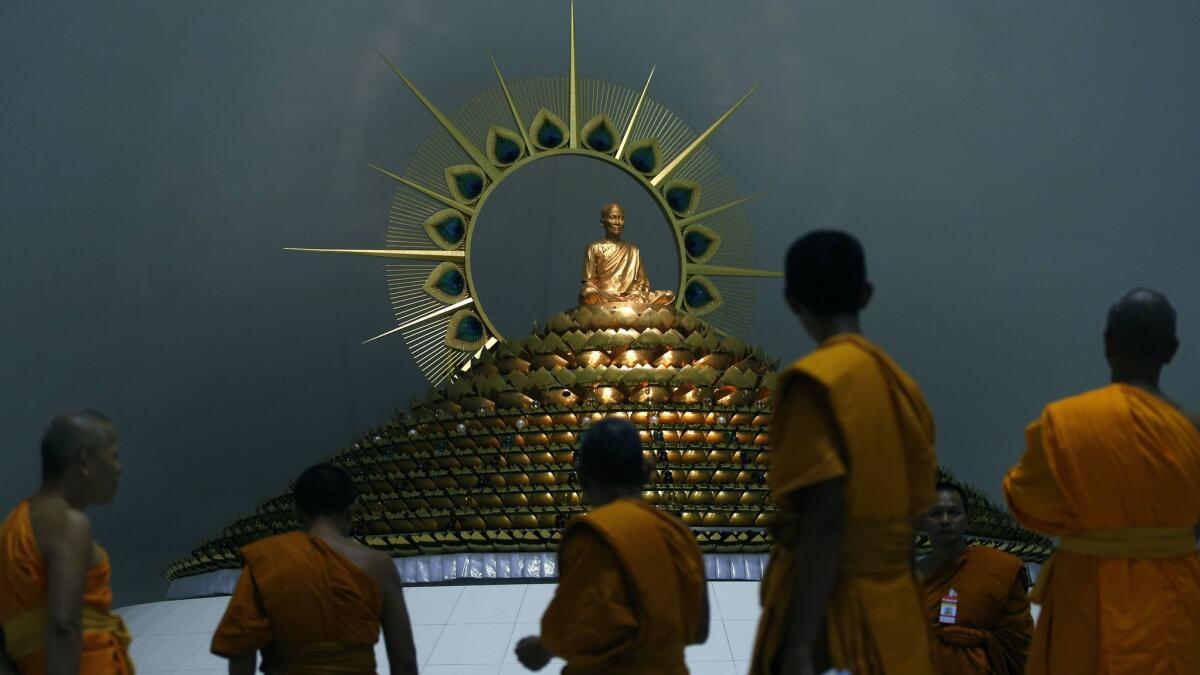 Buddhist monks walk together during a search inside Wat Phra Dhammakaya Temple in Pathum Thani province, on the outskirts of Bangkok.