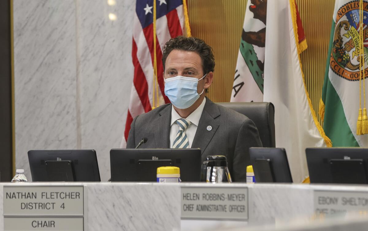 Chair of the County Board of Supervisors Nathan Fletcher wears a mask at a board of supervisors meeting in May