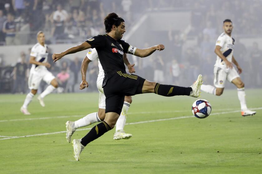 Los Angeles FC's Carlos Vela, center, takes a shot on goal during the second half of an MLS soccer match against the Los Angeles Galaxy, Sunday, Aug. 25, 2019, in Los Angeles. (AP Photo/Marcio Jose Sanchez)
