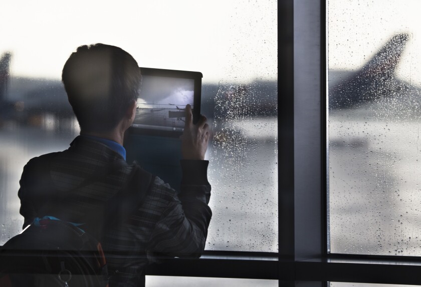 A man takes a photograph through a window of Sheremetyevo airport outside Moscow. NSA leaker Edward Snowden is believed to be stuck in the transit zone of the airport.