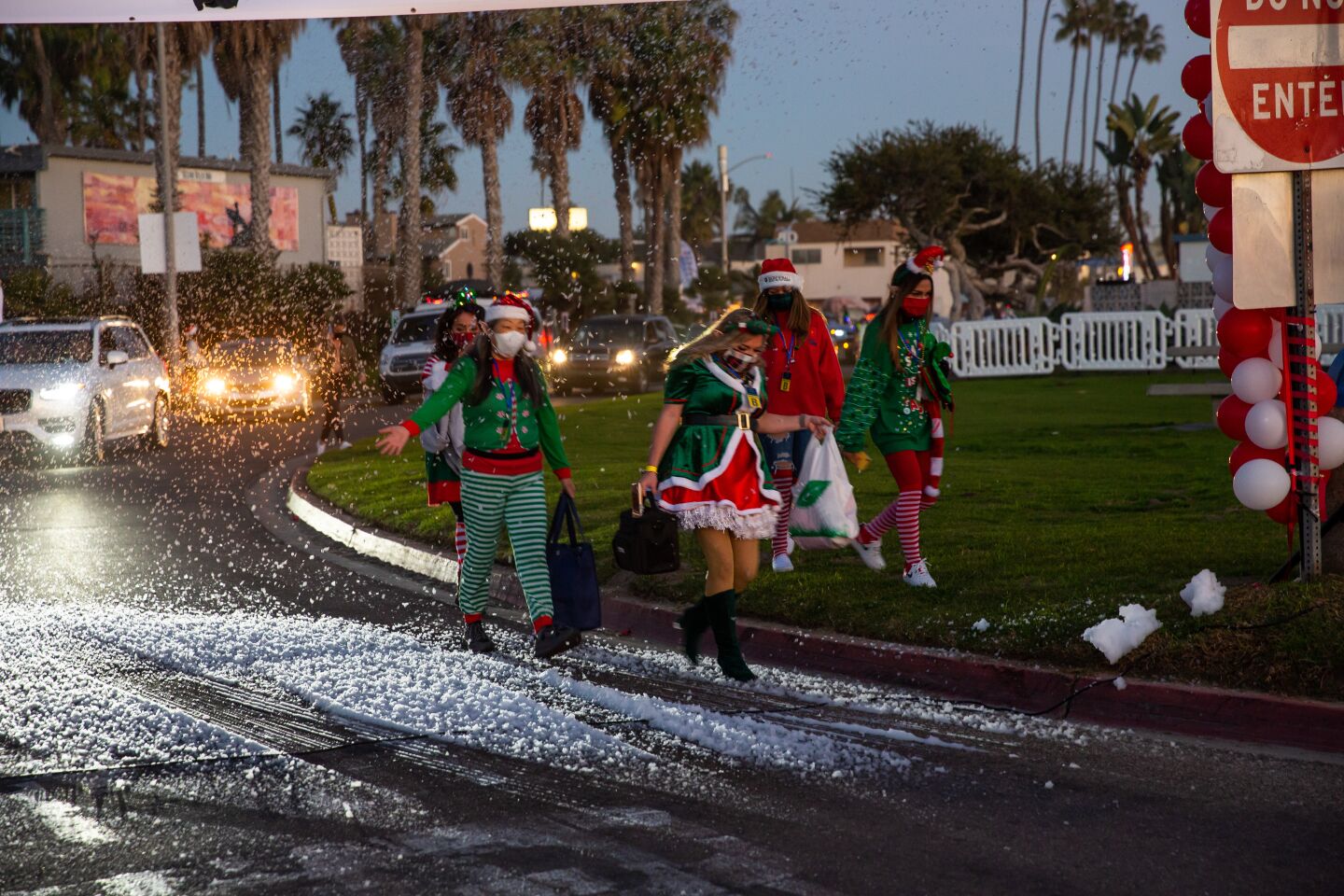 Merry elves make their way through the "snow" to the Ocean Beach Holiday Parade.