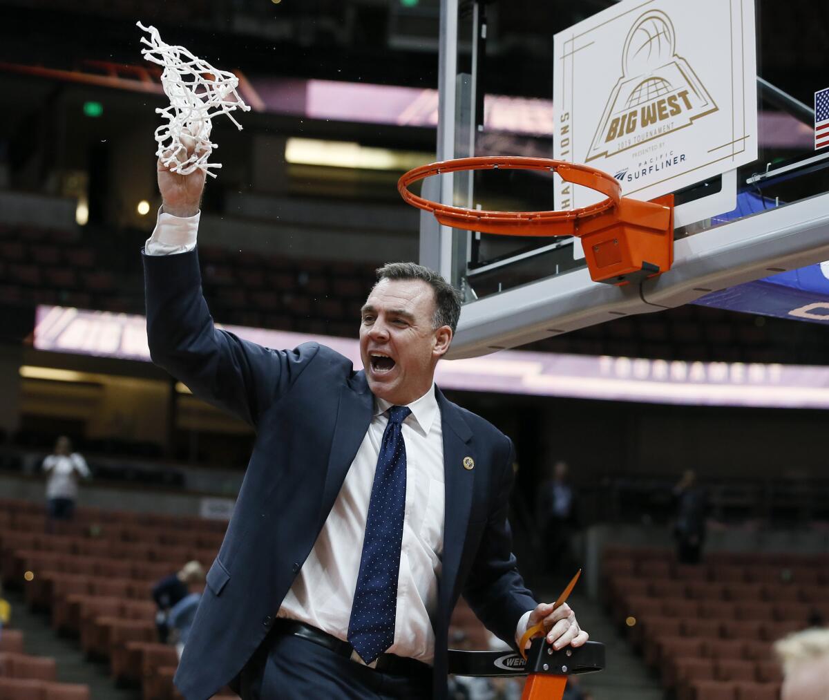 UC Irvine coach Russell Turner celebrates after cutting down the net as his team beat Cal State Fullerton 94-64 for the Big West Conference Tournament title at Honda Center on March 16.