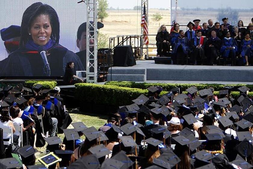 First Lady Michelle Obama, projected on a LED screen, gives the keynote speech for UC Merced's first full graduating class, foreground, on May 16, 2009.