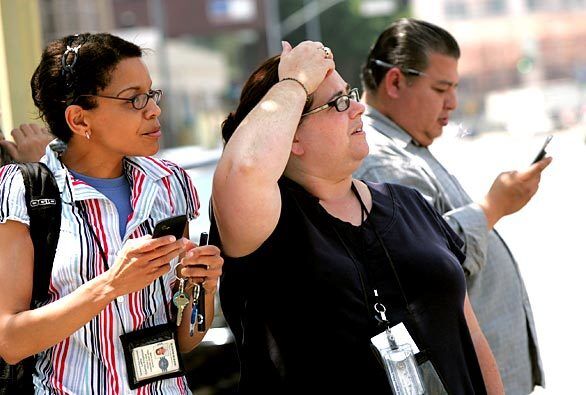 Celine Dove, left, Jennifer Keir and Tony Ortiz of the Los Angeles Police Department react to the earthquake in downtown Los Angeles.