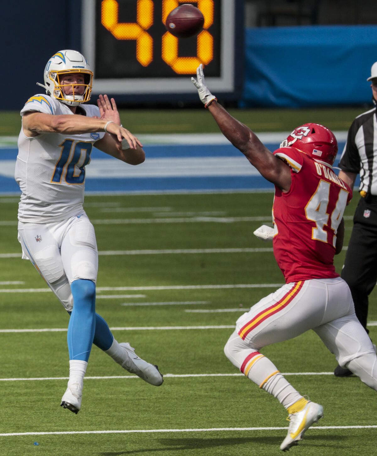 The Chargers' Justin Herbert  launches a pass over Chiefs linebacker Dorian O'Daniel.