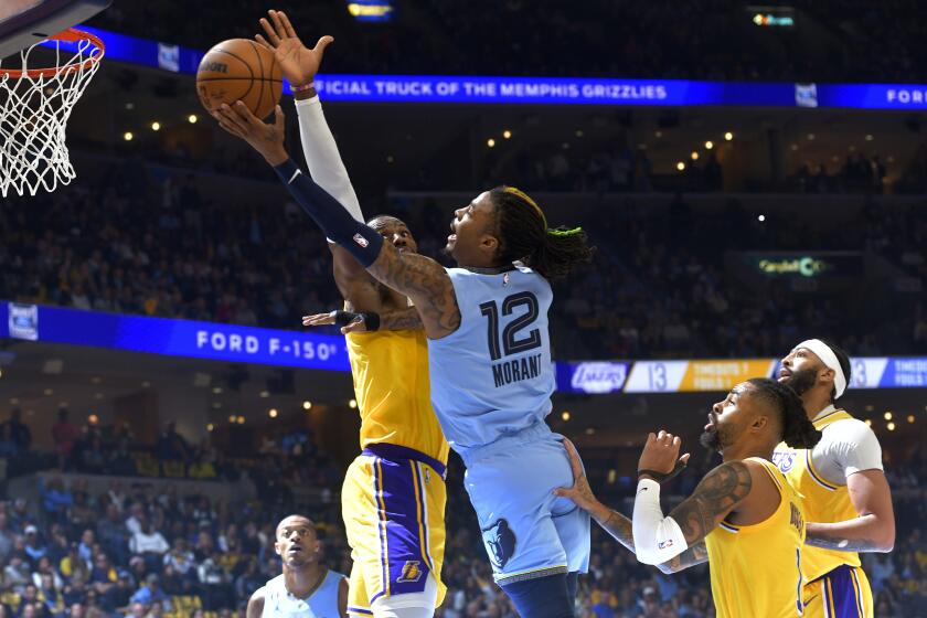 Memphis Grizzlies guard Ja Morant (12) shoots against Los Angeles Lakers forward LeBron James during the first half of Game 5 in a first-round NBA basketball playoff series Wednesday, April 26, 2023, in Memphis, Tenn. (AP Photo/Brandon Dill)