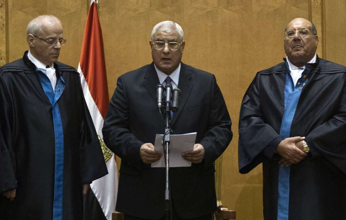 Adly Mahmoud Mansour, head of Egypt's Supreme Constitutional Court, takes the oath of the presidency in a court chamber in Cairo.